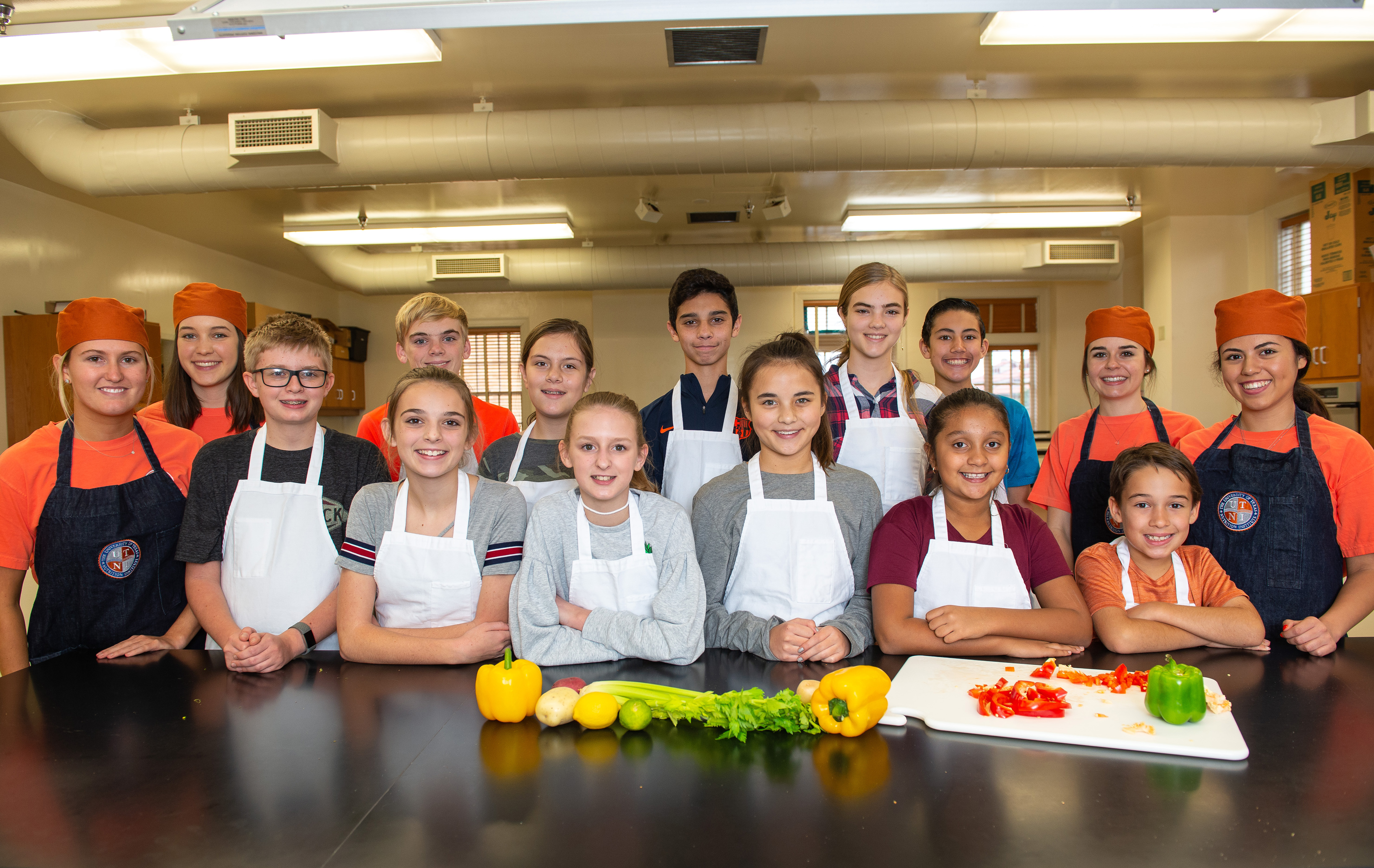 A group of children in aprons smile in Gearing Hall